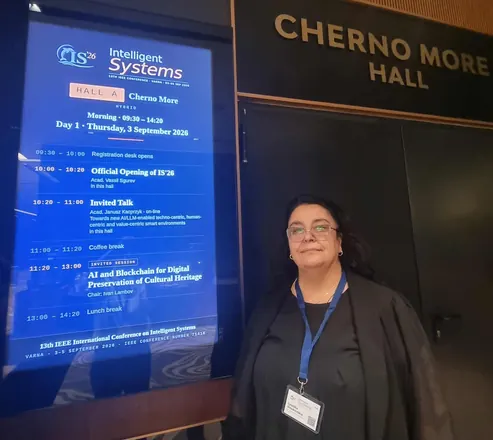 Participant beside the programme screen of Cherno More Hall